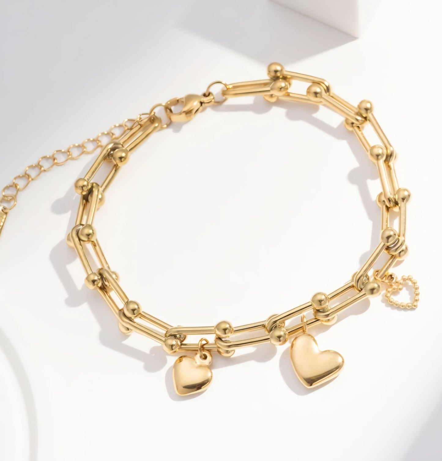 Justerbart guldarmband med tre hjärtberlocker i rostfritt stål